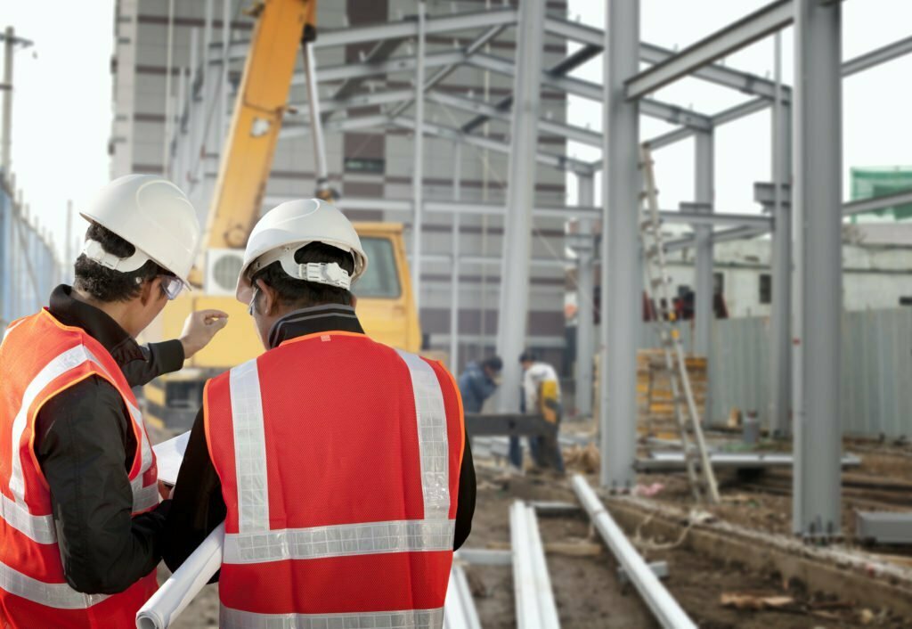 two new york construction workers going over plans for building