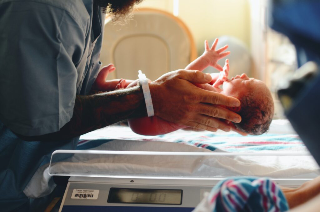 nurse handling new born baby after birth injury