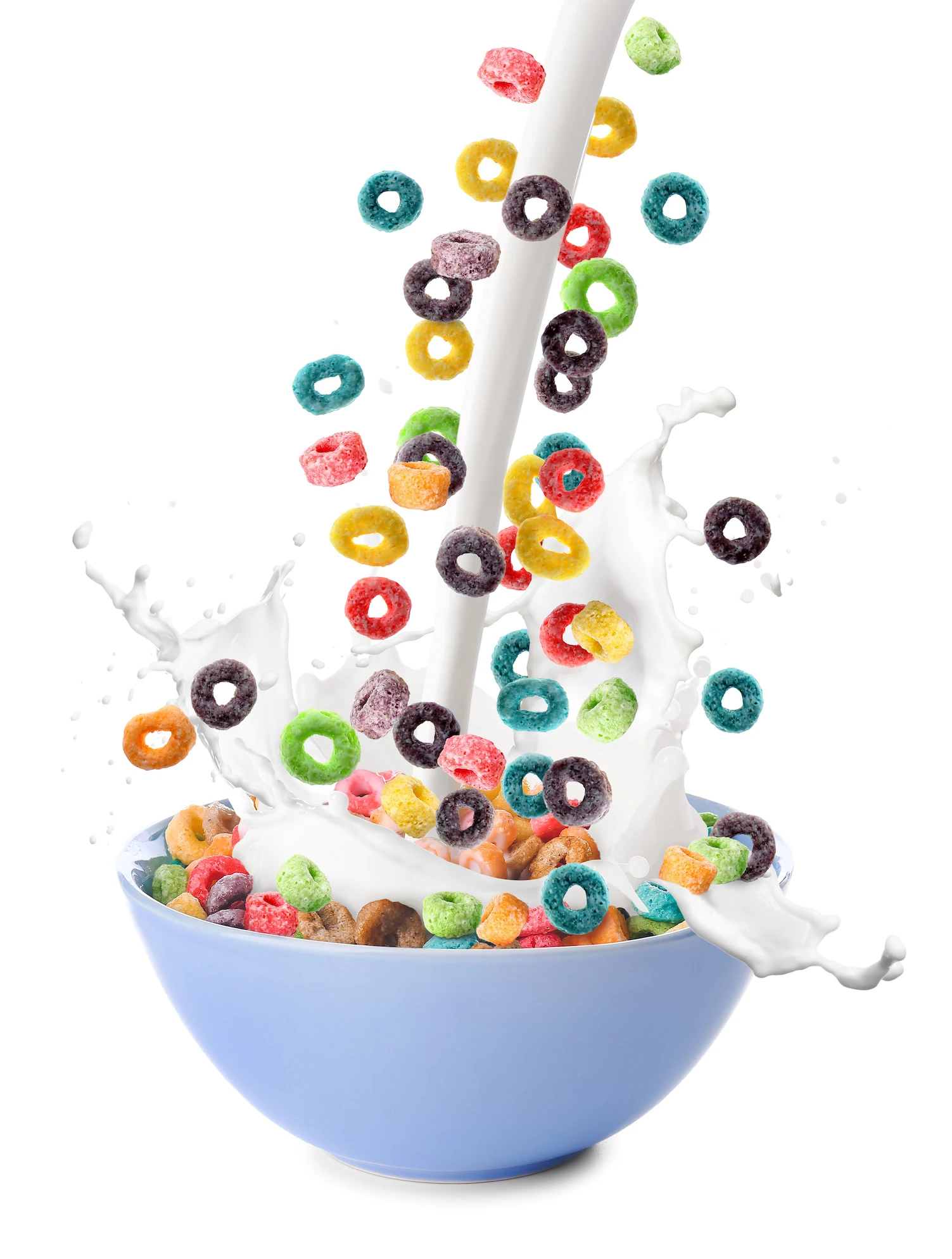 Pouring milk in bowl of colorful cereal rings on white background Pouring of tasty corn rings and milk into bowl on white background