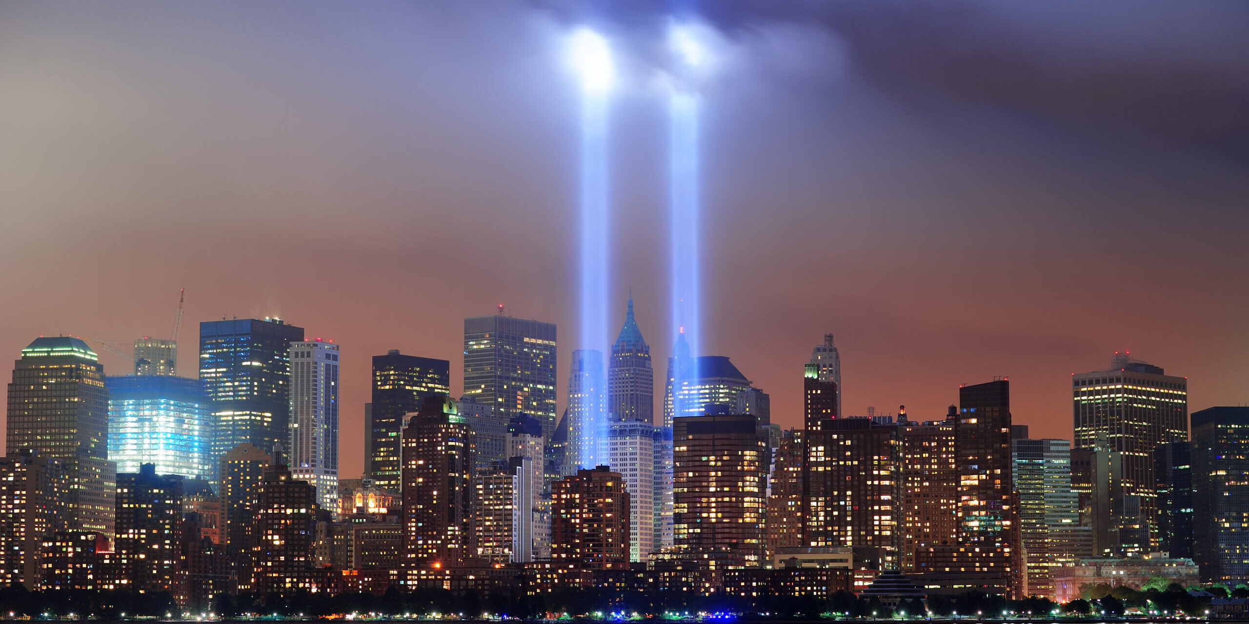 New York City night New York City Manhattan downtown skyline at night from Liberty Park with light beams in memory of September 11 viewed from New Jersey waterfront.